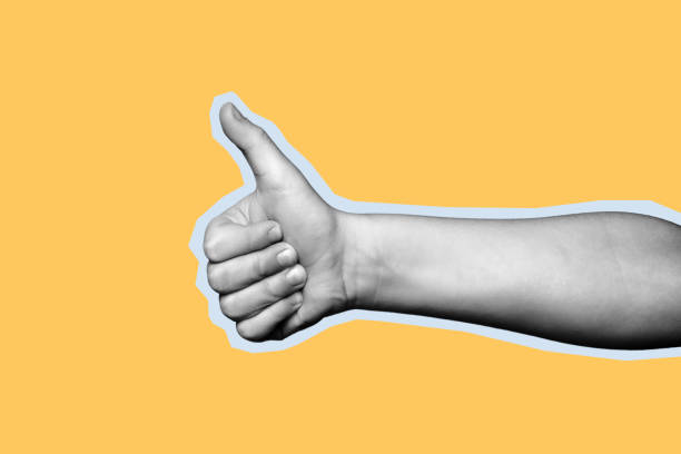 istock Child hand shows thumb up on yellow background. 1217269952