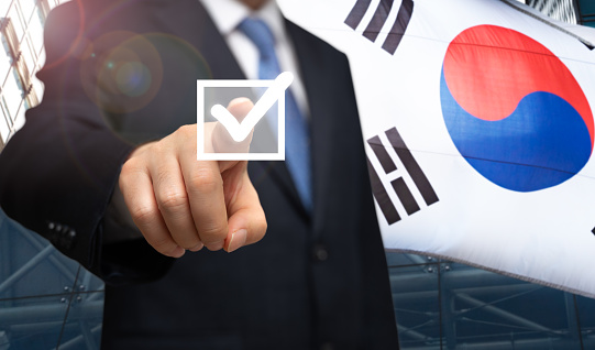 South Korea election concept. A businessman's election campaign against the backdrop of a Korean flag.