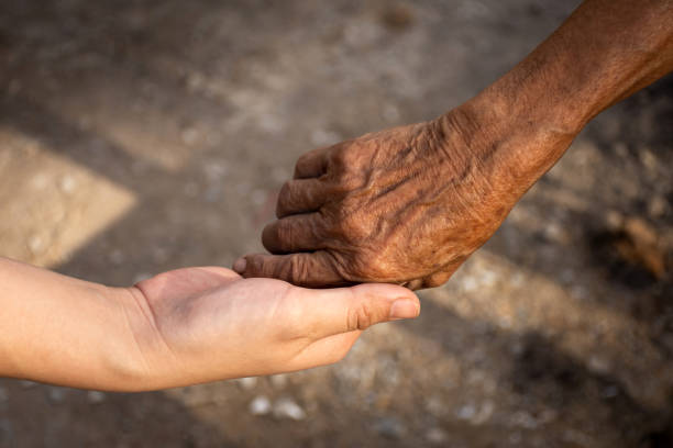 istock Young woman hand holding elderly person's hand. 1217275971