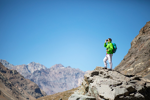 Man mountaineering in Los Andes mountain range. Lifestyle image of a person trekking trails outdoors as a recreational pursuit and sport activity.