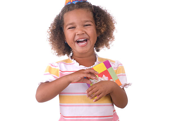 childhood, fashion, birthday, holidays and people concept - happy smiling african american little baby girl with birthday party hat looking up at something