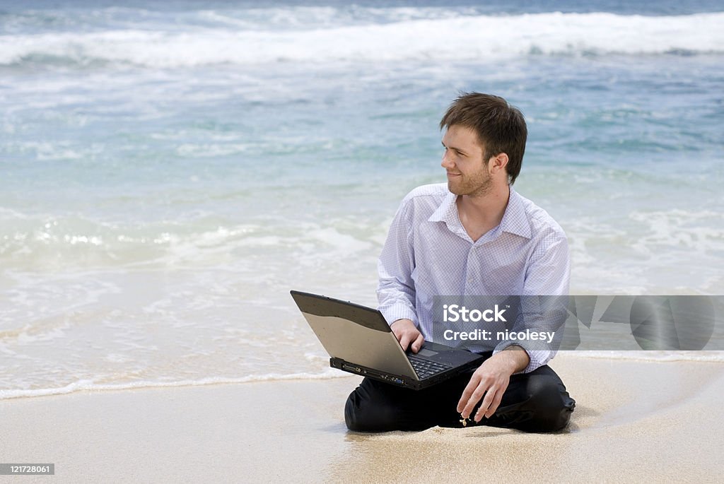 Człowiek z komputerem na plaży - Zbiór zdjęć royalty-free (20-29 lat)