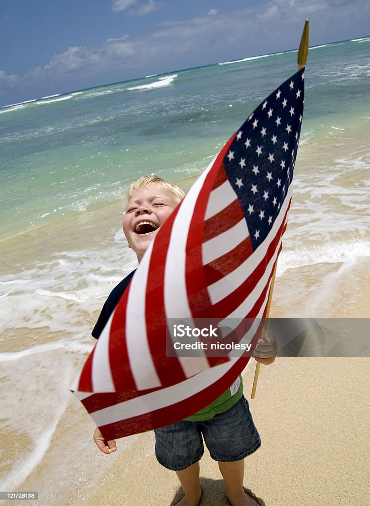 Menino com a bandeira americana em uma praia - Foto de stock de Bandeira Norte-Americana royalty-free