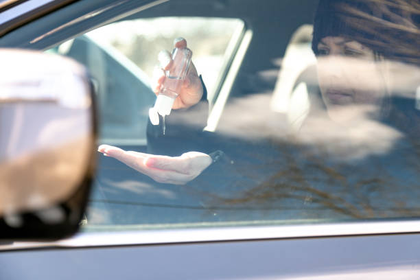 istock Woman using hand sanitizer while sitting in car 1217282708