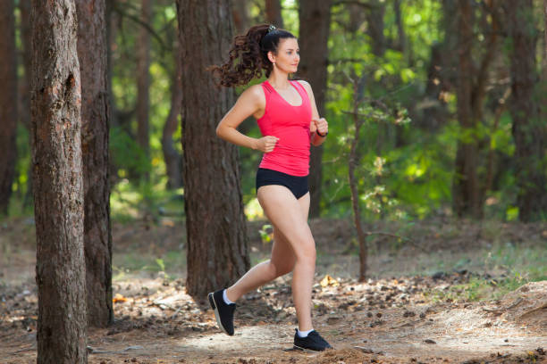 istock Young woman runner training alone outdoors in the summer forest 1217284428