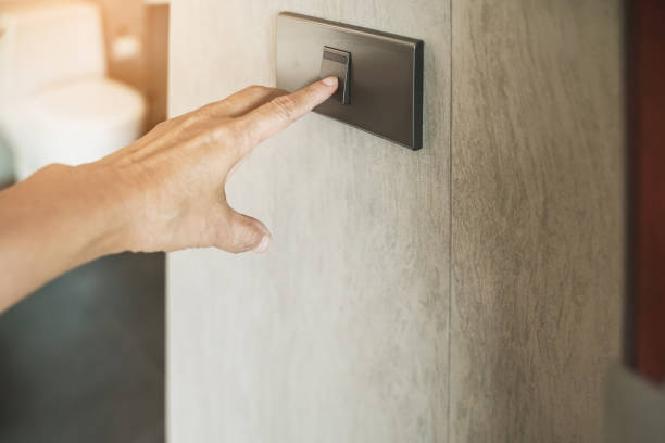 istock old woman's  hand turned on switch to open light in toilet, in soft focus 1217285600