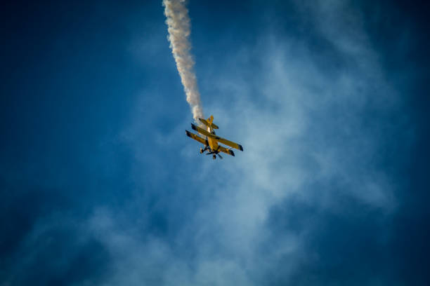 喫煙バイプ - airplane stunt yellow flying ストックフォトと画像