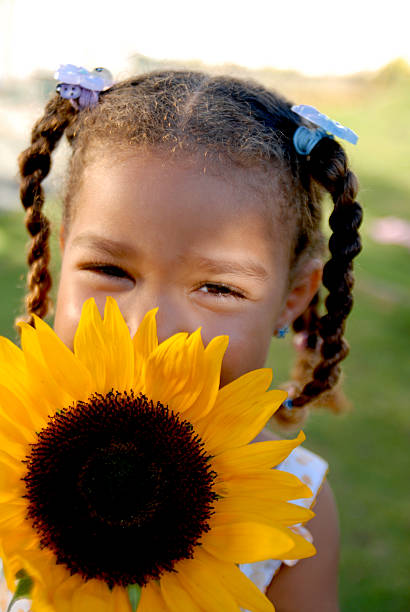 Closeup of a lady laughing while looking at the sun standing in a field of flowers. Concept of the image is a healthy lifestyle of a attractive, energetic woman who is happy, relaxed, and positive when surrounded by nature, a person who enjoys life.