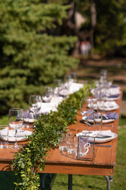 istock Preparing for an open-air party. Decorated with fresh flowers served tables. Table number. Decoration Details 1217288098