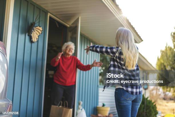 Volwassen Volwassen Vrouw Leveren Boodschappen Aan Senior Volwassen Vrouwelijke En Sociale Distantiëring Als Gevolg Van Infectieuze Virus Uitbraak Pandemie Stockfoto en meer beelden van Delen - Begrippen