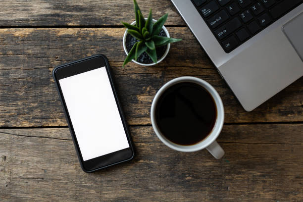 istock close up Blank Screen of Smartphone and Computer on Wooden Table top view. with clipping path 1217303363