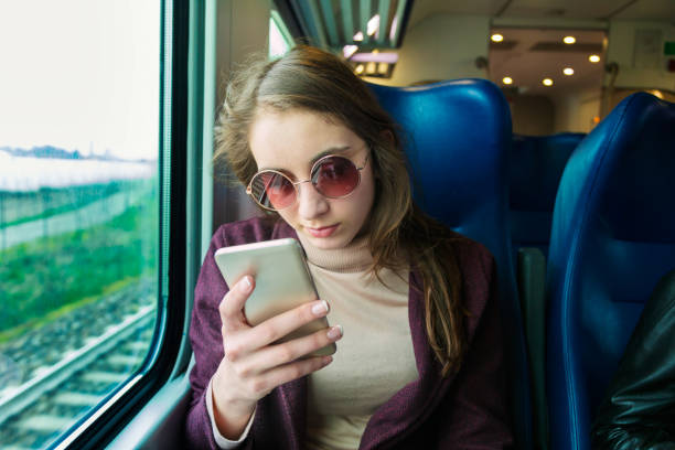 istock Young girl using smart phone in subway train 1217304236