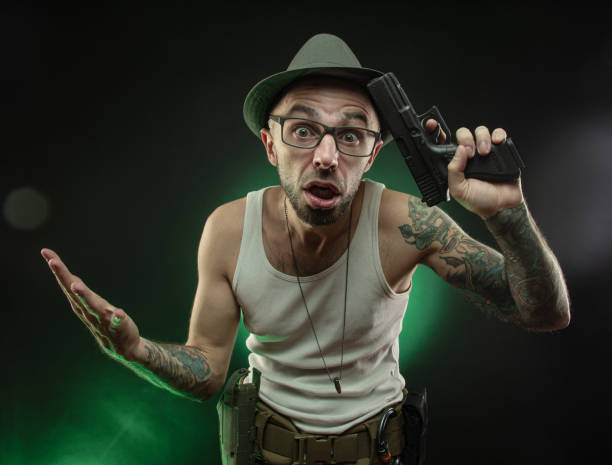 istock an athletic guy with a tattoo poses with a pistol 1217305417