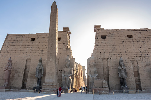 Luxor, Egypt - 27th Dec 2019: The colossal statues of Ramesses the Great and obelisk at the first pylon of Luxor Temple