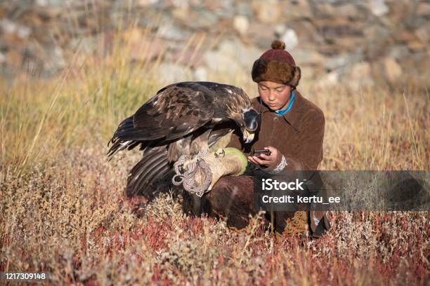 Young Kazakh Eagle Hunter With His Golden Eagle Stock Photo - Download Image Now - Independent Mongolia, Telephone, Inner Mongolia