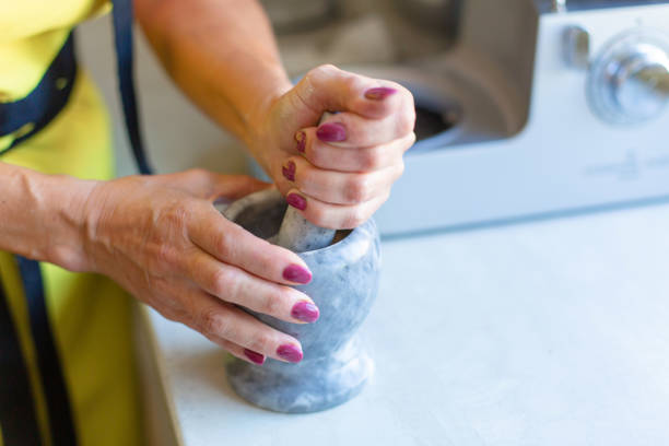 istock A woman grinds nuts in a mortar. Seasoning making 1217310388