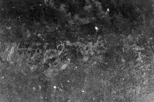 Moon surface - uneven porous structure with visible defects - black abstract background of rough imperfect concrete wall - beautiful stone material