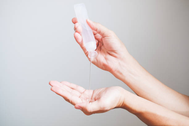 istock Man hands using wash hand sanitizer gel dispenser 1217312494