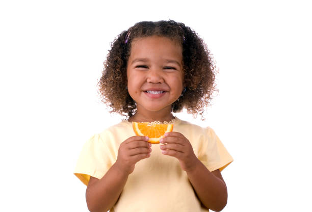 istock Girl Eating an Orange on White Background 121731262