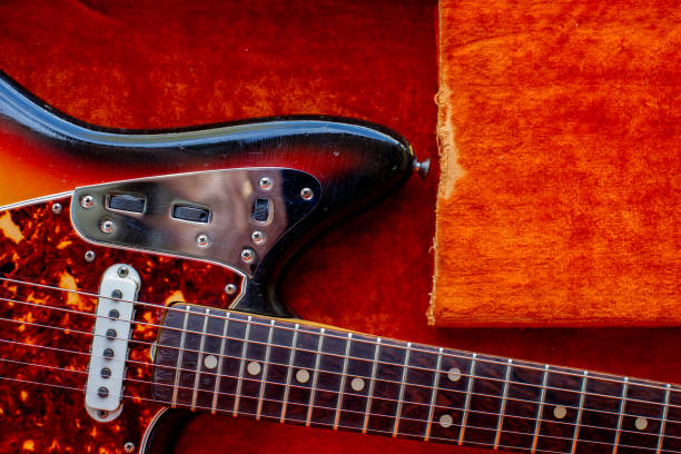 Vintage orange interior. Guitar m with rosewood fingerboard.  Contrast with orange background. 1960’s era.  Vintage Guitar