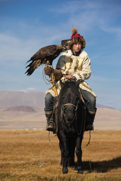 istock Kazakh eagle hunter with his golden eagle and horse. 1217314171