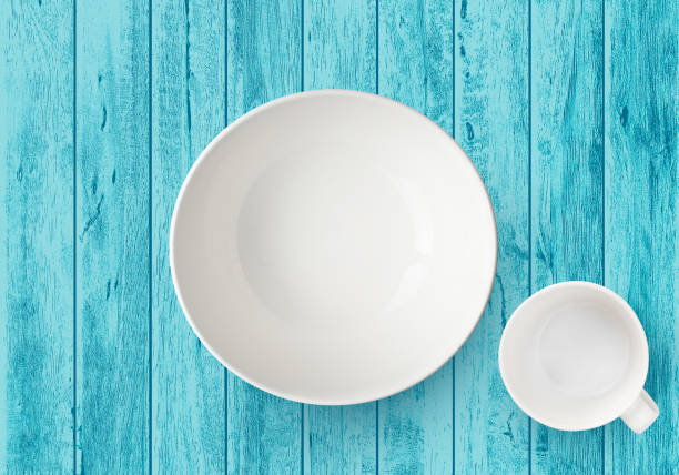 istock top view of empty white plate and cup isolated on blue wood table 1217315321