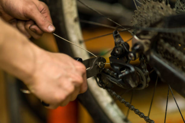 istock A bicycle mechanic is repairing a bicycle wheel, closeup. 1217323068