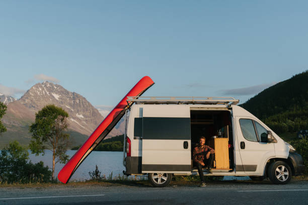 istock Man near the camper van with canoe on roof 1217323513