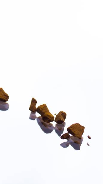 istock Ground brown coffee beans on a white mirrored surface. 1217324588