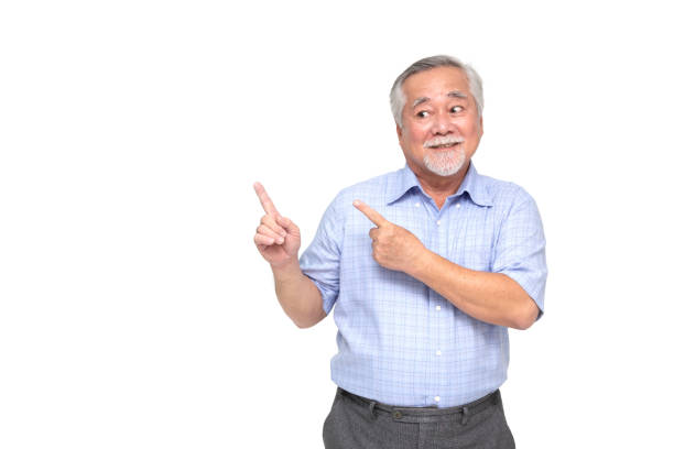 Asian senior man smiling and pointing to empty copy space isolated on white background