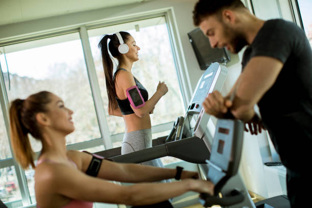 istock Young woman using treadmill in modern gym 1217326444