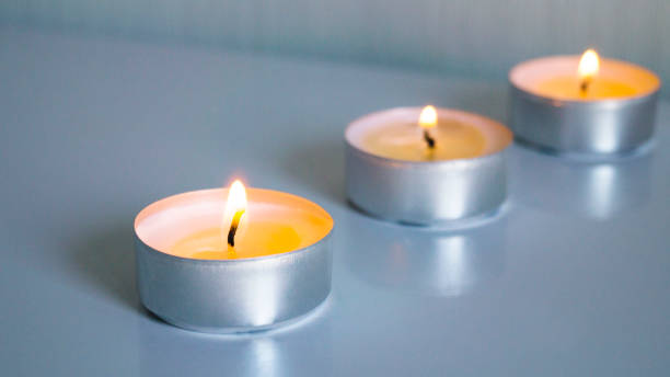istock Three small burning candles on a light background. Focus on the first candle. 1217326767
