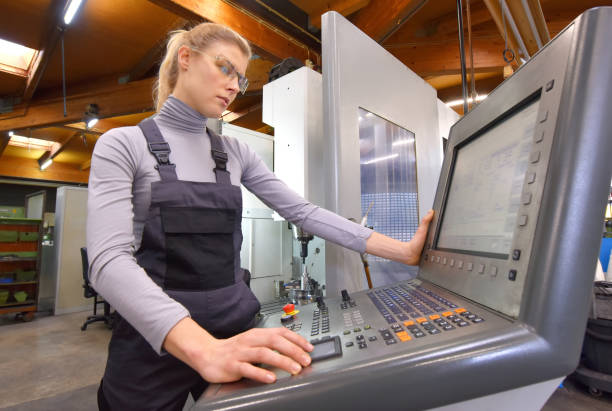 Industrial Computer Controller A young woman works as an industrial
computer controller. She is seen at
her workplace wearing a blue overall. switchboard operator stock pictures, royalty-free photos & images