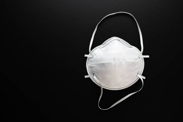 istock Coronavirus protection. White antibacterial medical mask on a black background 1217331421
