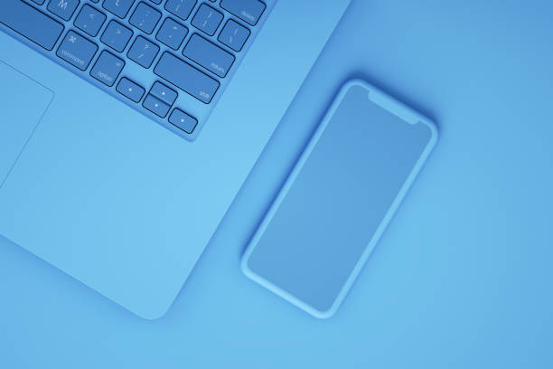 istock Empty Screen Smartphone and Laptop on Blue Background 1217332711