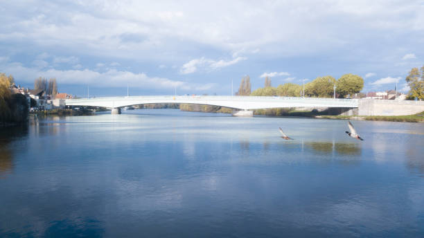 istock bridge over river joining two banks, one of which is civilized 1217333380