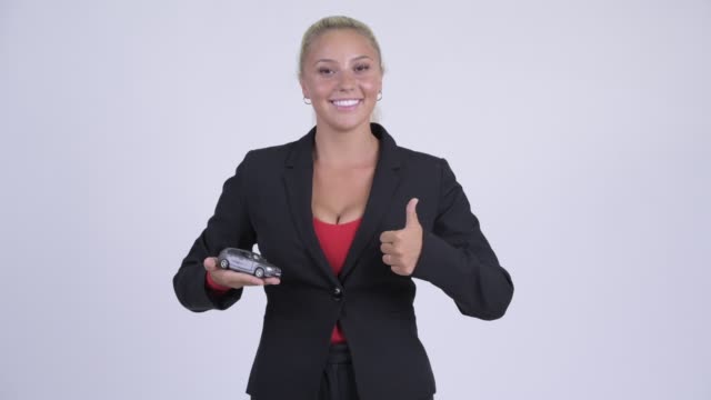 Happy young blonde businesswoman with toy car