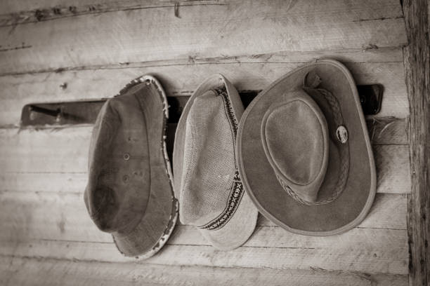 istock Three old hats on hatrack on outside wooden wall. 1217334201