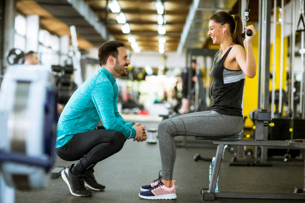 istock Young beautiful woman doing exercises with personal trainer 1217338104