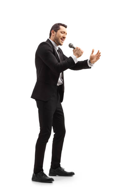 istock Man in a black suit singing on a microphone 1217338997