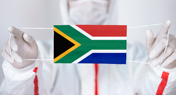 Healthcare personnel is holding South African Flag shaped surgical mask.