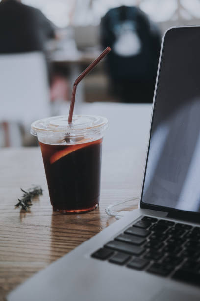 istock Black iced coffee with a notebook on wood table. Coffee break beverage cafe drinking enjoyment concept 1217341929