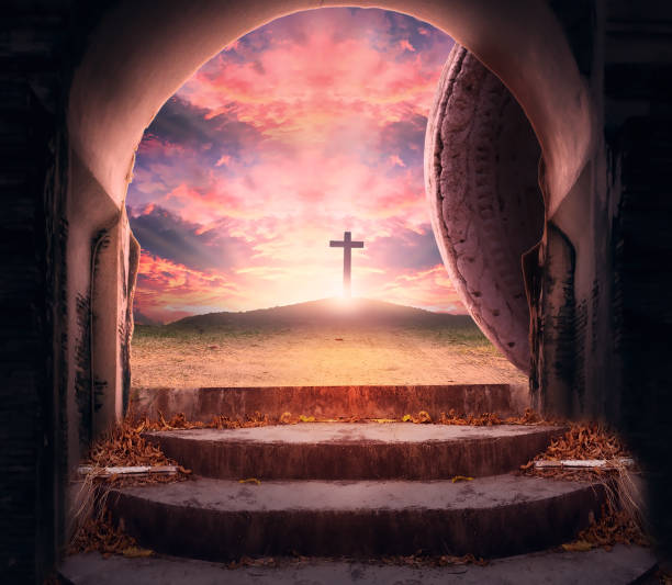 Easter Sunday concept: Tomb empty with cross on sunset background stock photo