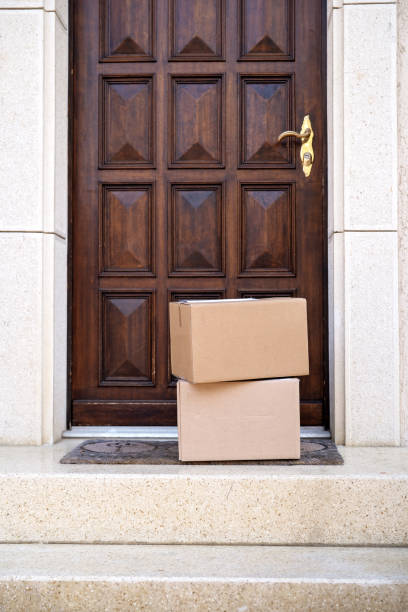 istock Contacless delivery service during quarantine. Two carton boxes delivered and left oudside ar entrance door. on stairs. Mock up 1217344624