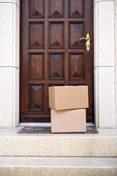 Contacless delivery service during quarantine. Two carton boxes delivered and left oudside ar entrance door. on stairs. Mock up stock photo