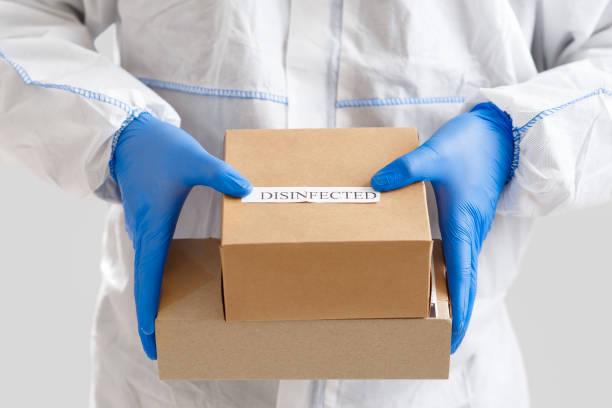 istock Man holding boxes in gloves. Delivery service under quarantine 1217345715