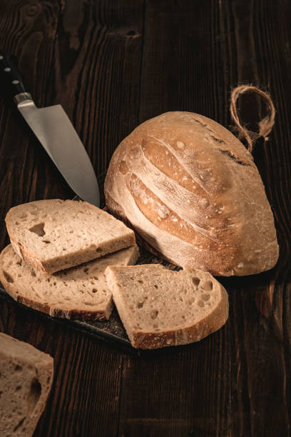 istock Fresh homemade bread on an old wooden table table. Dark background. 1217345720