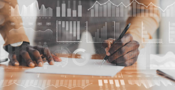 istock African American businessman working with document, collage with double exposure of graphs on digital screen 1217345807