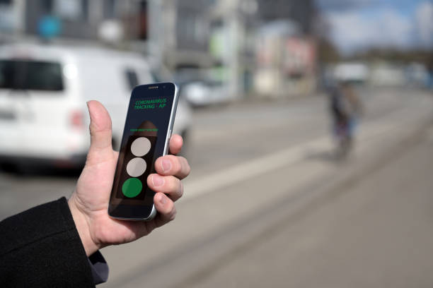 istock Hand of a man is checking his smartphone with a coronavirus tracking app, that monitors contacts between people and shows the risk of infection, blurry city street background, copy space 1217346421