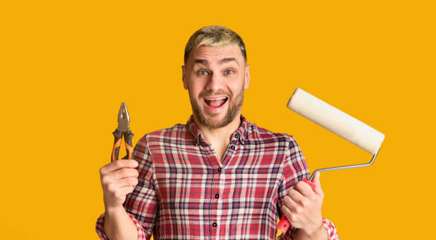 istock Guy holds pliers and roller in his hands 1217346557